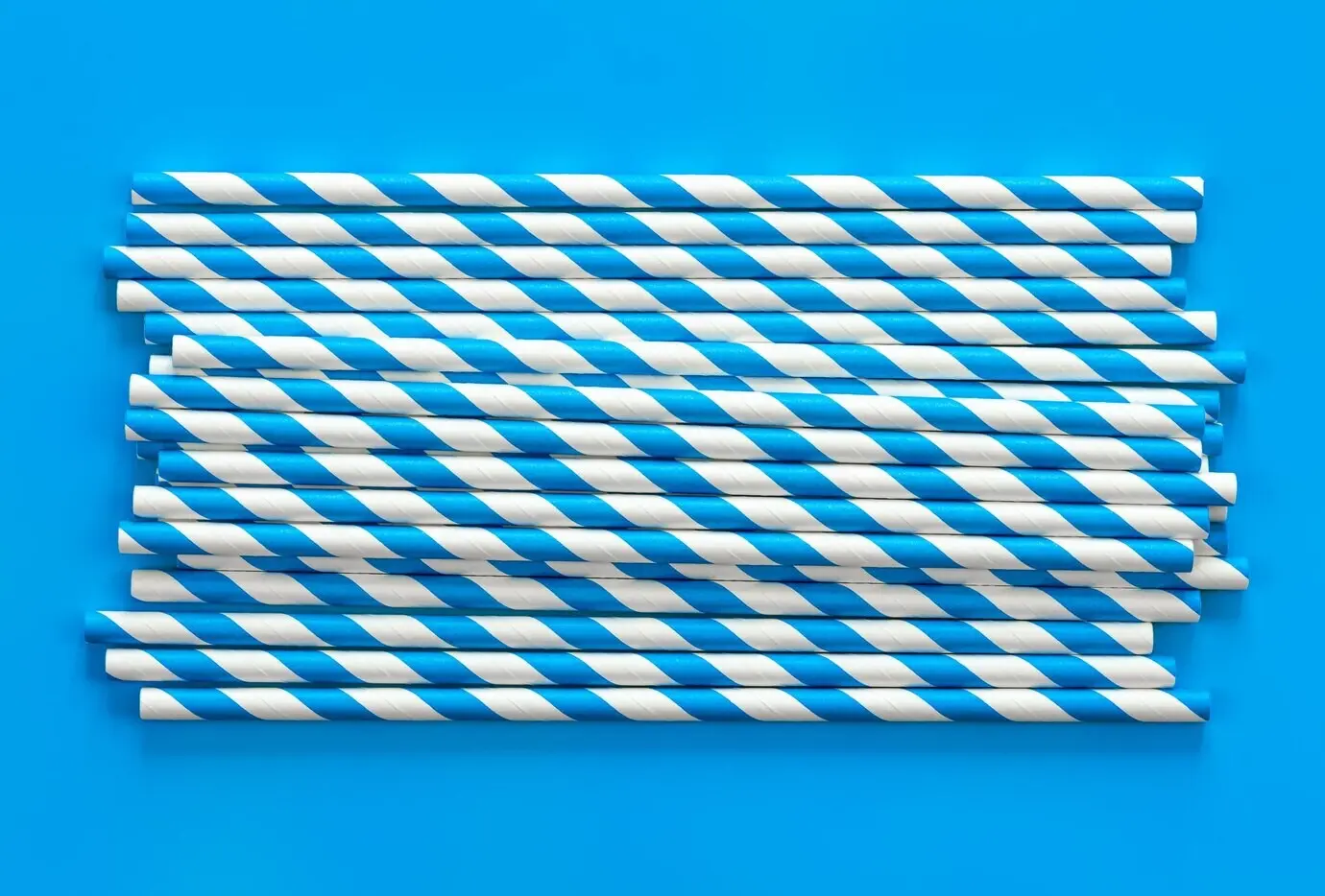 Flat lay of party drinking straws on a blue background